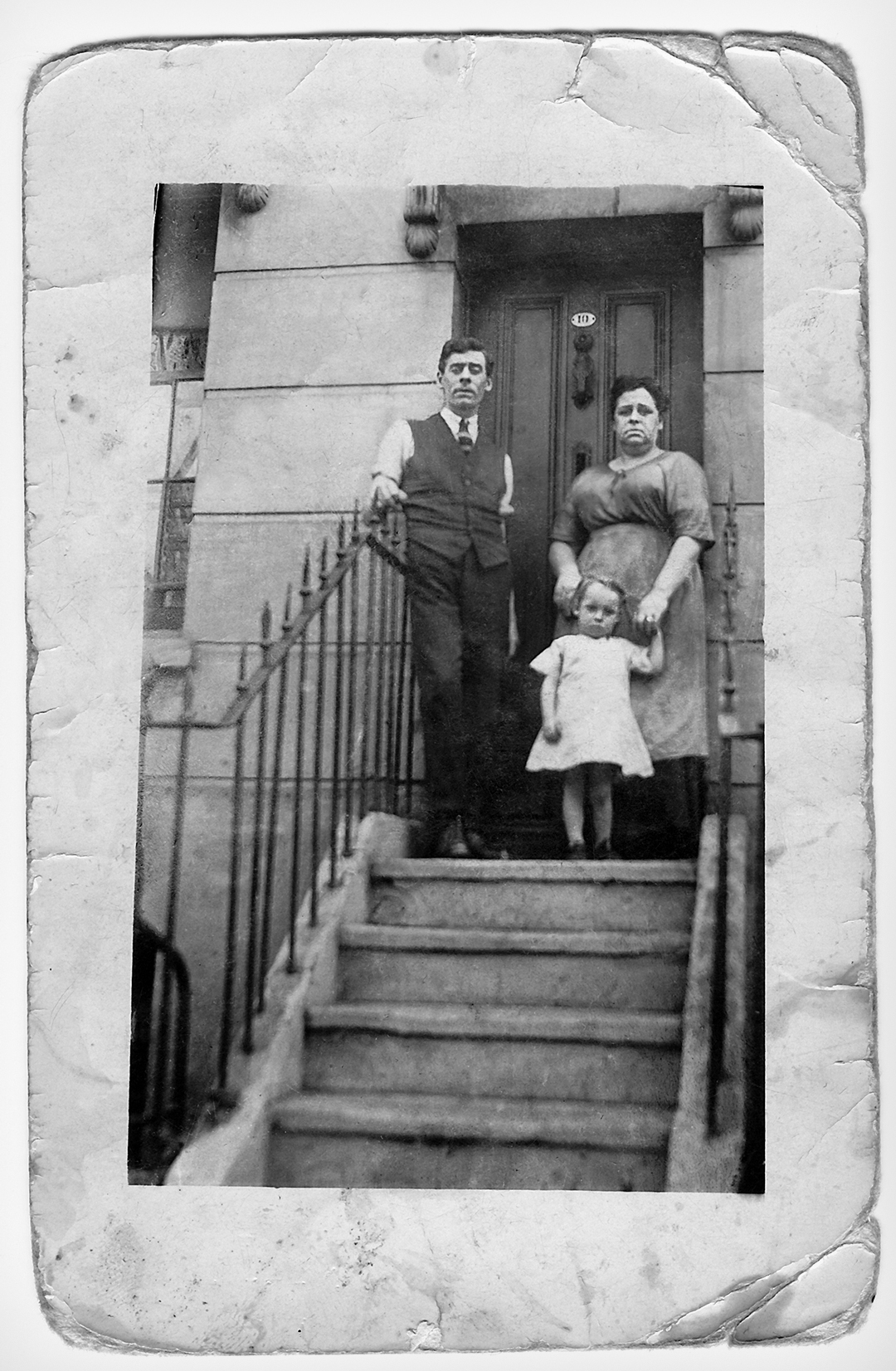 Retored photograph family on house steps early 1900s